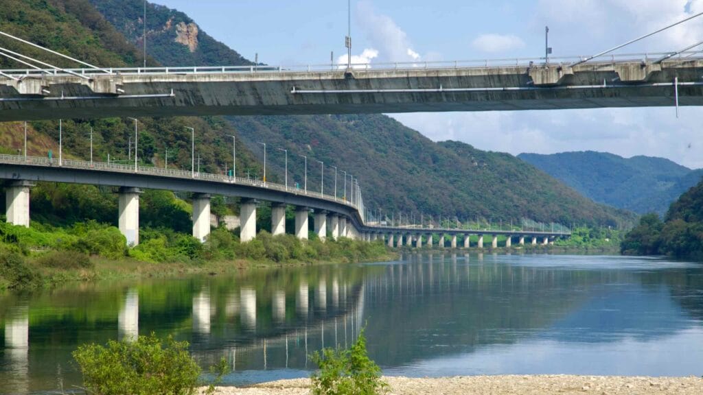 Twin viaducts follow the North Han River canyon below Gangchon Grand Bridge, their piers reflecting in calm water.
