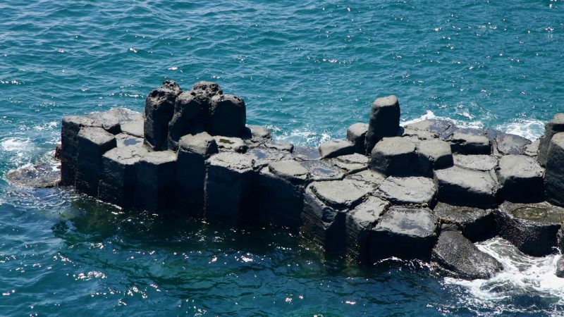 Isolated basalt outcrop in the sea at Jusangjeolli Cliffs.