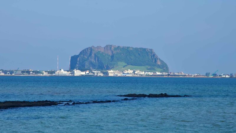 Seongsan Ilchulbong rises above the waterfront across the calm waters of Songnan Port.