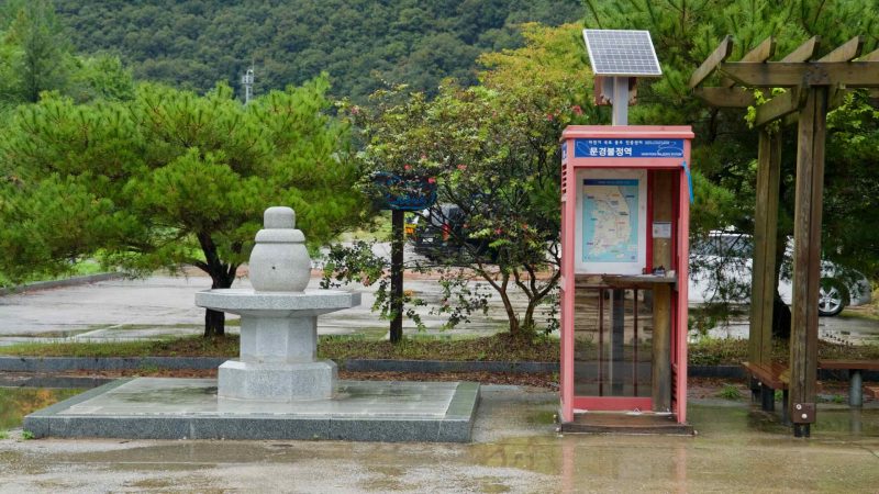 A stamp booth and stone pagoda stand at Buljeong Station after rain.