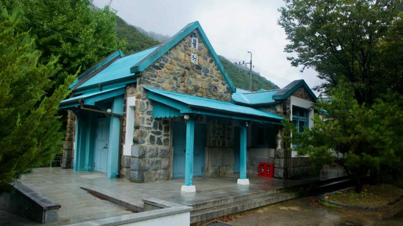 Fieldstone Buljeong Station with teal roofs glistens on a rainy day.