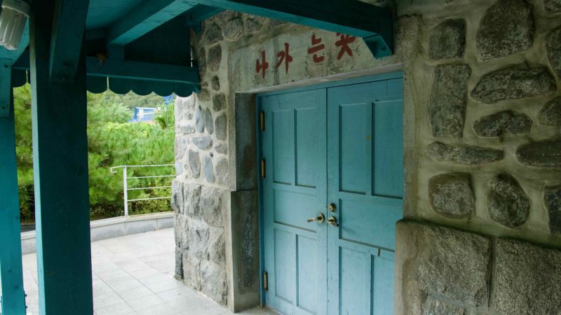 Teal double doors sit beneath the sheltered porch at Buljeong Station.