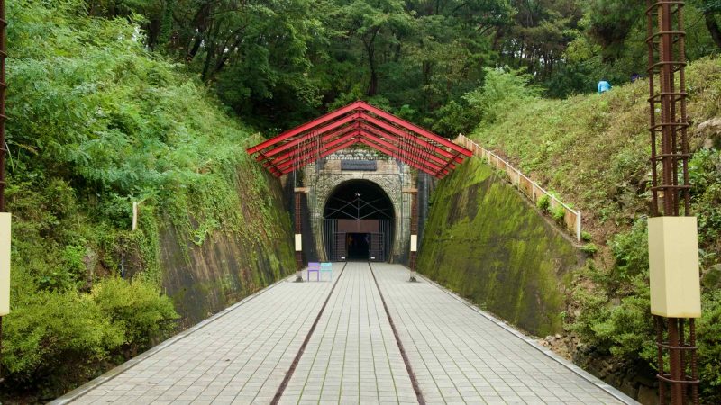 The Omija Theme Tunnel stone arch and red canopy mark the start of the themed walkway.