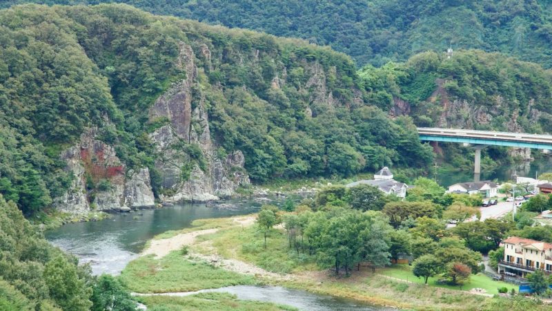 Across a green valley, mist clings to ridges while the Yeong River winds below the fortress.