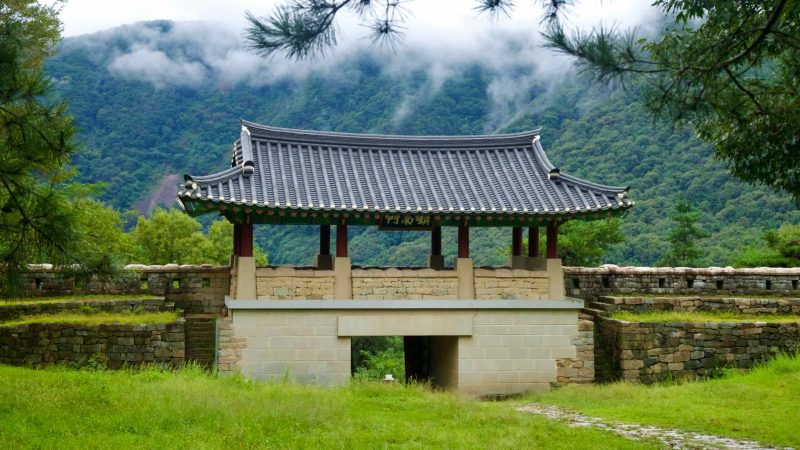 A tiled-roof gatehouse spans a stone arch at Gomo Mountain Fortress.