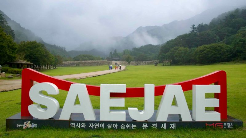 A large ‘SAEJAE’ sign overlooks the rainy parade ground at Mungyeong Saejae Fortress.