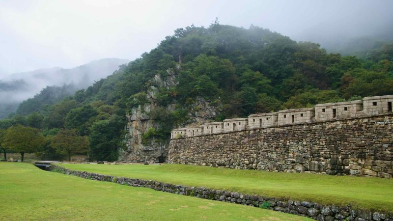 Fog curls over the ridge beside Mungyeong Saejae’s stone ramparts.