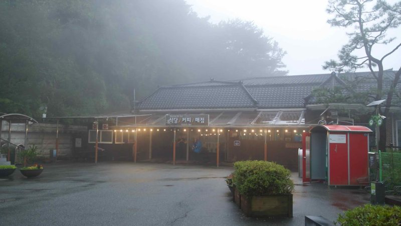 String lights warm the Ihwaryeong Rest Area restaurant and café in mountain mist.