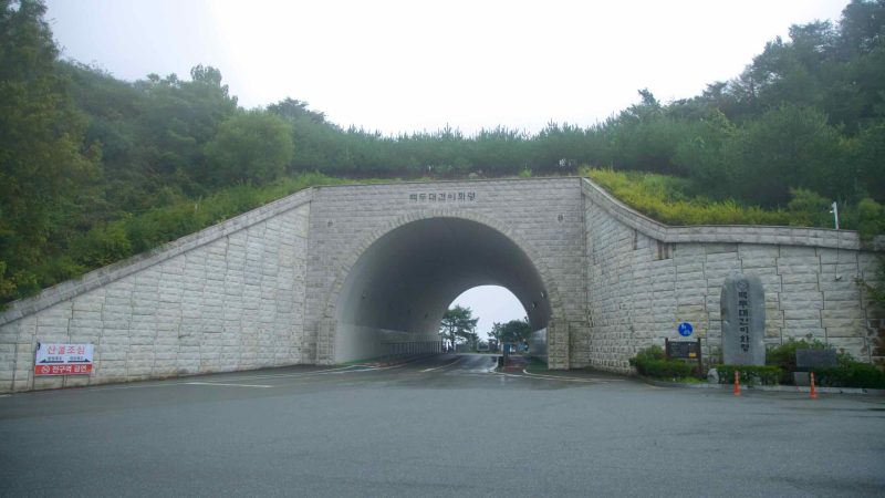 The stone-faced portal of the Baekdudaegan Ihwaryeong Tunnel crowns the summit road.