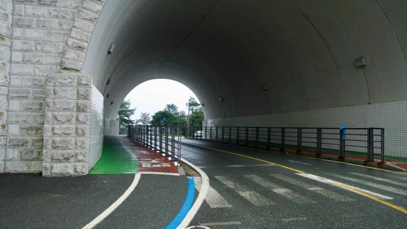 Inside the Ihwaryeong Tunnel, traffic lanes run beside a protected bike path.