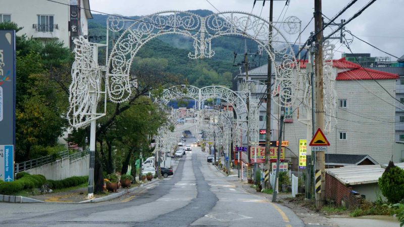 Lighted arches line the main street in Suanbo Township beneath forested hills.