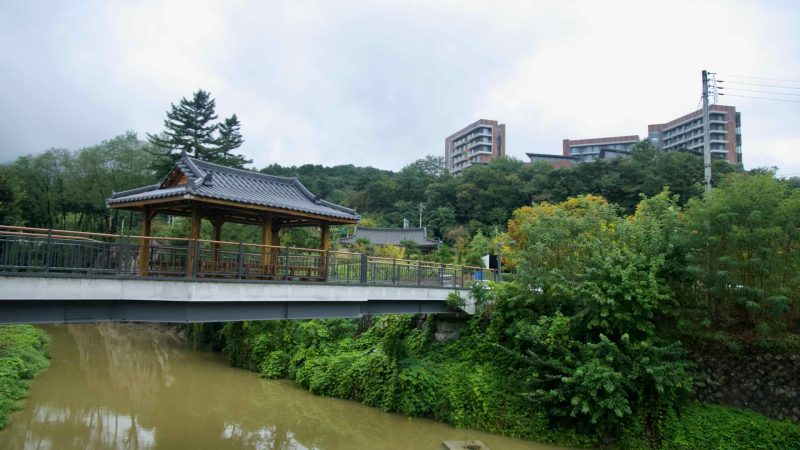 A traditional pavilion stands on a bridge over Seokmundong Stream in Suanbo.