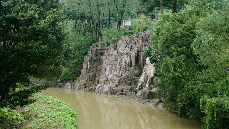 Jagged rock faces crowd a quiet bend of the stream near Suanbo.