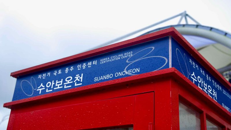 The Suanbo Oncheon cycling road stamp booth stands quiet after rain.
