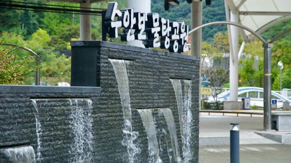 A tiered water wall flows beside the amphitheater canopy at Multang Park.