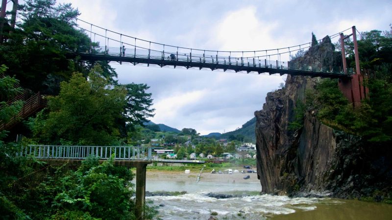 A suspension footbridge crosses Sujupal Peaks above the Dalcheon in Chungju’s Jinnamgyoban bend.