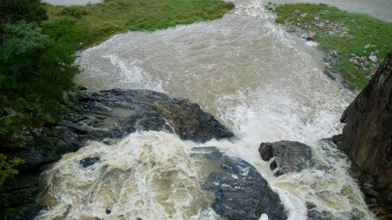 Water foams over dark rock at Kal Rock Falls before spilling into an eddy at the base of Sujupal Peaks’ cliffs.