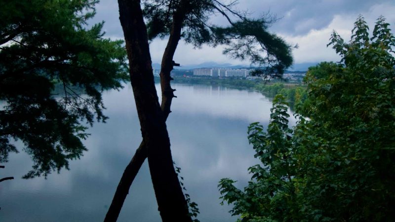 A calm reach of the South Han River spreads below Tangeumdae Park, with Tangeumdae Yeoldudae and towers beyond.