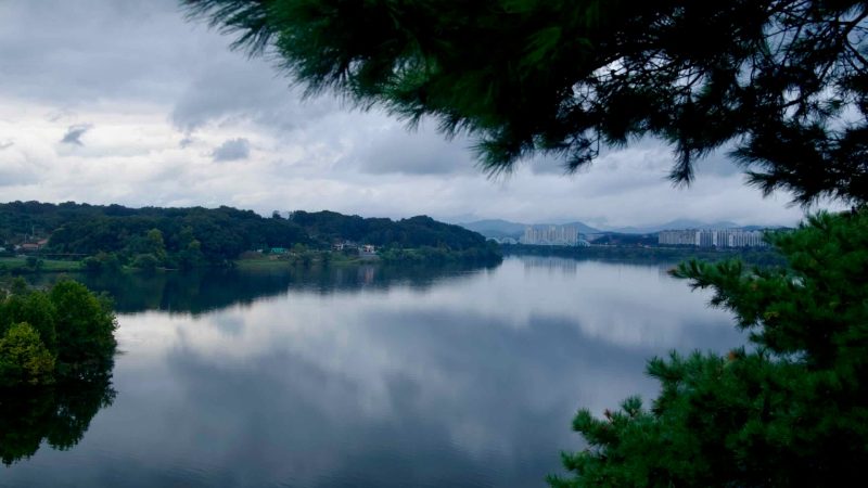 The South Han River widens below Tangeumdae Park, with apartment towers and wooded hills lining the distant bank.