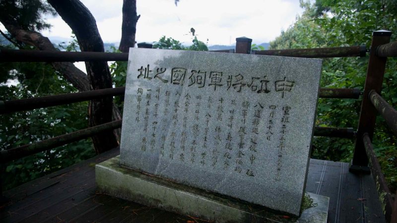 A granite plaque carved with Korean text stands beside the overlook rail at Tangeumdae Park, facing the river.