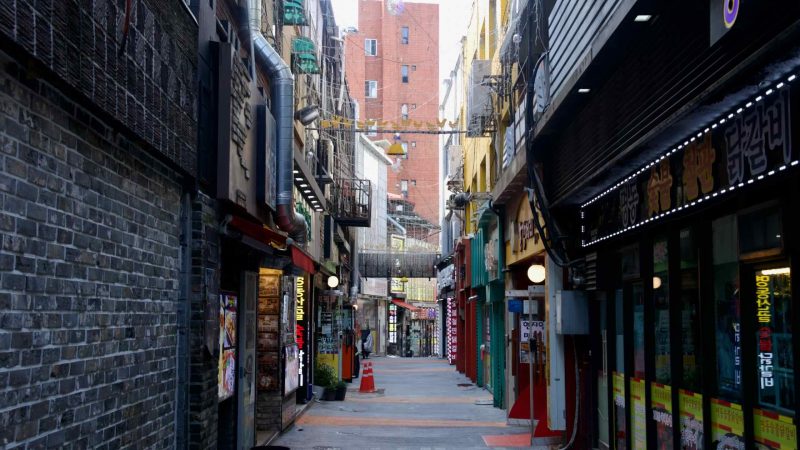 A restaurant lane lined with exhaust ducts runs behind kitchens in Chuncheon’s food district.
