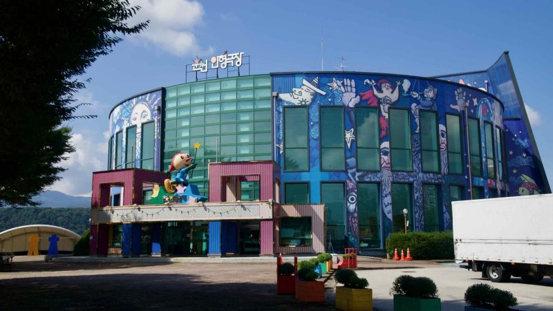The mural-covered Chuncheon Puppet Theater faces the plaza beside Uiam Lake.