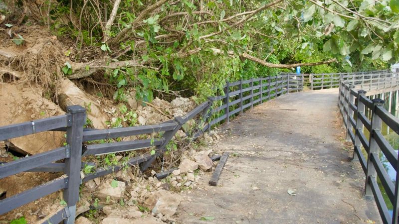 Landslide debris crowds the railing on the Uiam Lake boardwalk.