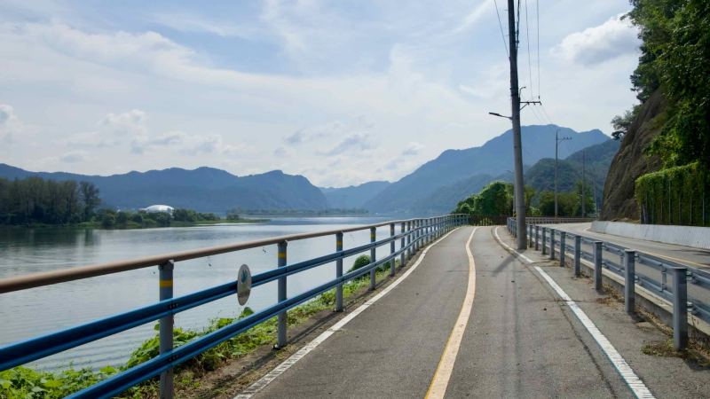 Riverside bikeway along the Bukhangang with mountains layered in the distance.
