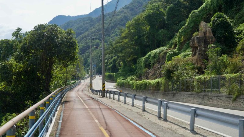 A riverside bike path climbs past a rock outcrop above the Bukhangang.