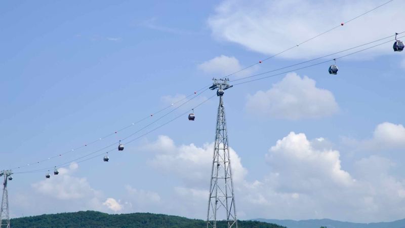 Gondolas on the Samaksan Lake Cable Car pass a high support tower above Uiam Lake.