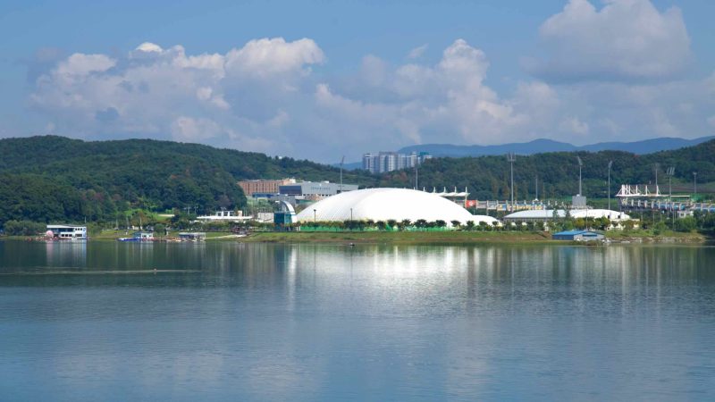 The white Sports Town dome shines over Uiam Lake with a clear reflection.