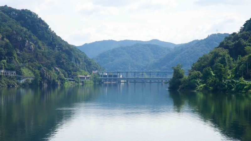 Rocky slopes and gallery tunnels lead toward Uiam Dam at the valley’s end.
