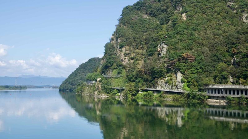 Steep, forested slopes and pale rock outcrops plunge to Uiam Lake below Samaksan, where a protective gallery road.