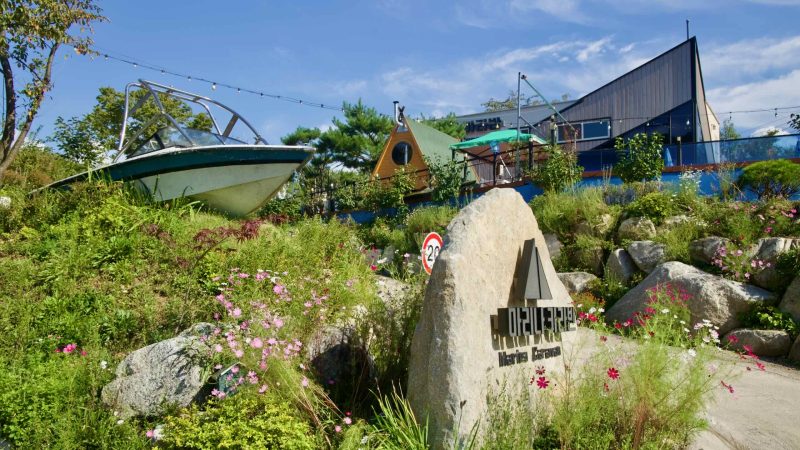 The Marines Caravan entrance features a display boat, flowers, and signs.