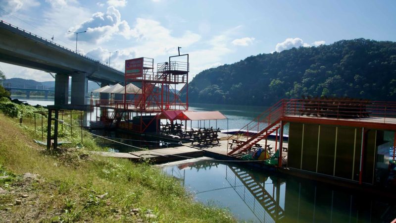 An old rail bridge crosses the river on sturdy concrete piers.
