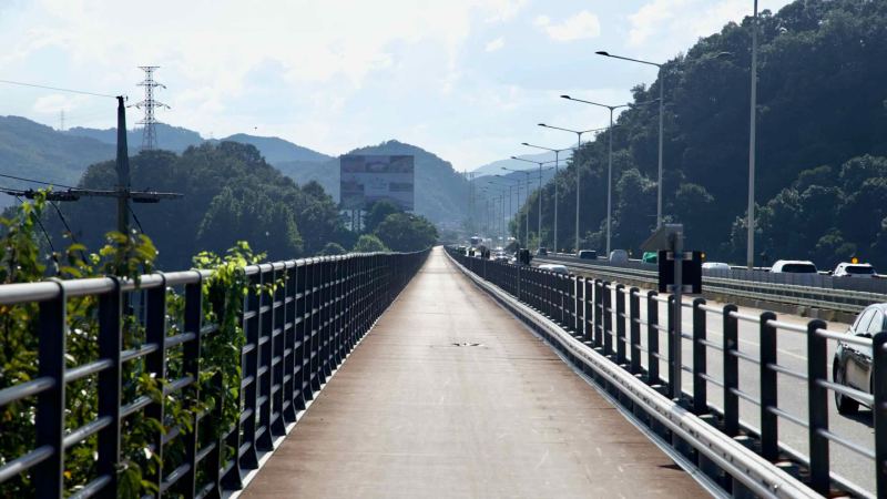 A cycle and pedestrian walkway runs beside traffic on Kyunggang Bridge over the Bukhangang.