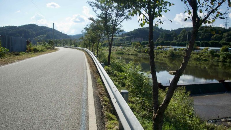 A freshly paved riverside section of the Bukhangang Bike Path traces Daljeon Stream in Gapyeong, with trees casting long shadows.