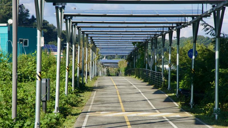 A closer view shows repeating posts and panels in the solar corridor over the Bukhangang Bike Path.