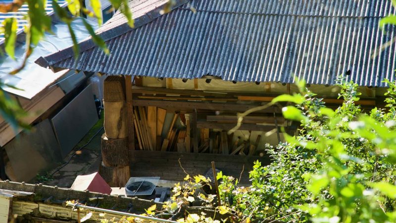 Stacks of timber rest inside a rustic shed with a corrugated roof in Sangcheon Village near Gapyeong, a glimpse of local rural life.