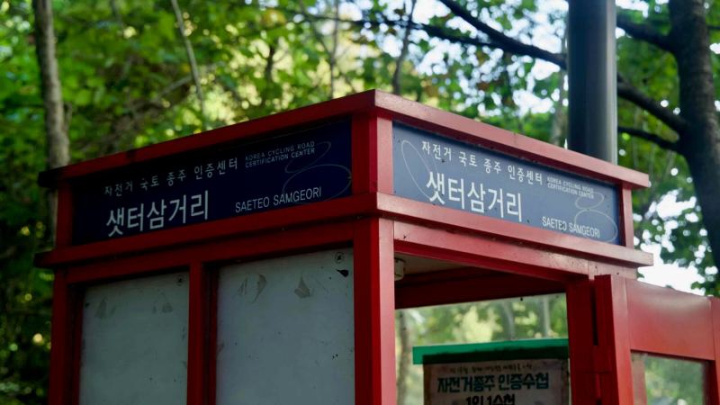 A close view shows the Saeteo Samgeori certification booth and its official signage beside the Bukhangang route.