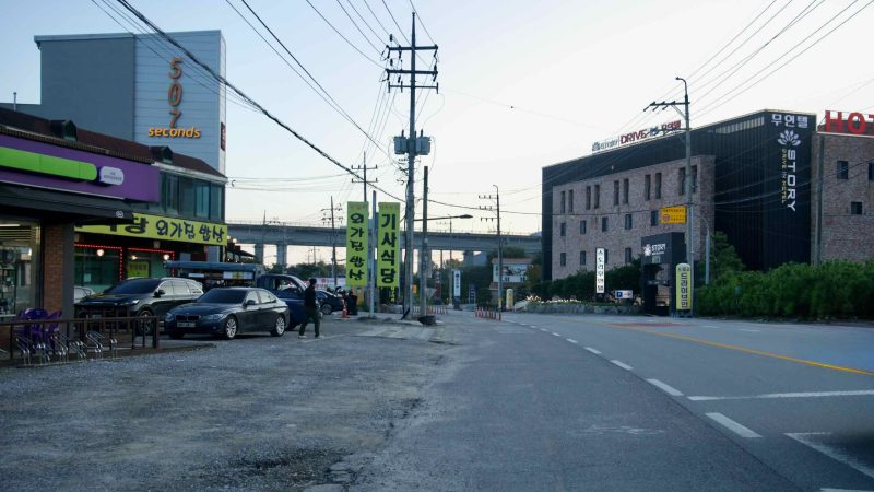 Roadside eateries and a hotel with bright signs line the bikeway corridor in Namyangju.