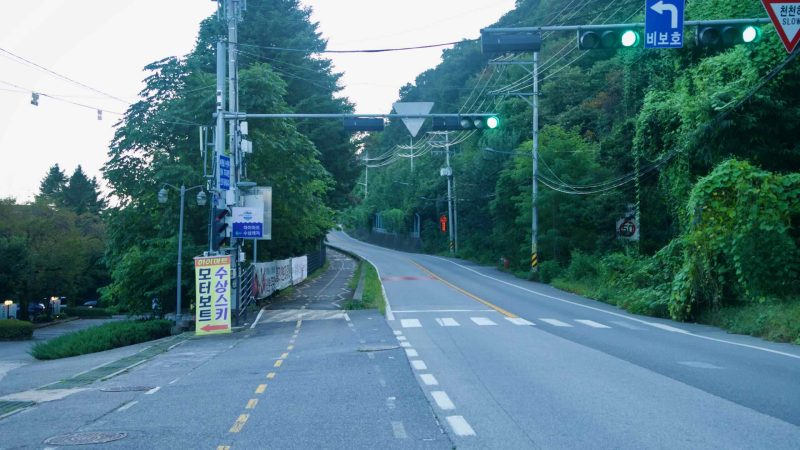 A quiet hill road and bike lane climb toward the Bukhangang waterfront in Namyangju.