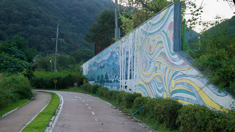 A colorful wall mural lines the Bukhangang bike path in Namyangju.