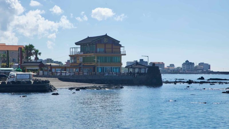 Temple‑style building and pavilion on a lava rock point.