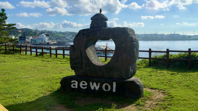A basalt frame spelling “aewol” faces the harbor from a viewpoint at Darak Shelter.