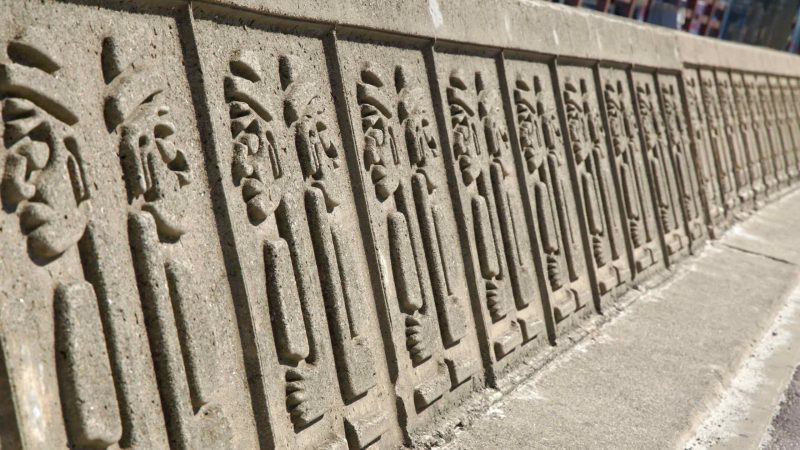 Dol hareubang relief panels along the Hyeopjae seawall.