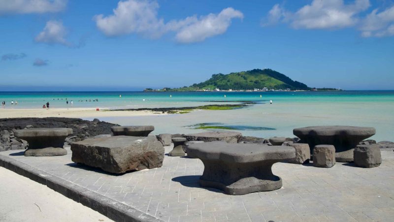 Basalt picnic tables on the Hyeopjae promenade facing Biyangdo.