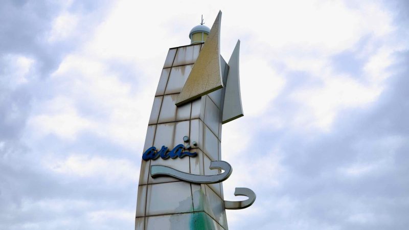 A detailed view of the sail-shaped sculpture at Duri Ecological Park, featuring the Ara Waterway logo against a cloudy spring sky.