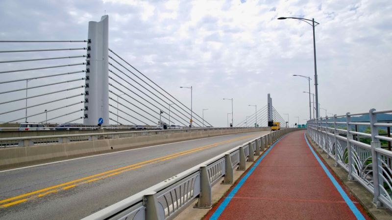 View of Jeonho Bridge's cable-stayed pylons and dedicated cycle lane as the crossing nears Ara Hangang Lock on the Gyeongin Ara Waterway.
