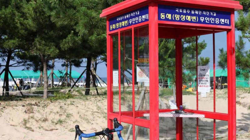 The Mangsang Beach Certification Center, where cyclists stamp their passports to track adventures along Korea's cross-country routes, set against sandy grounds and pine trees.